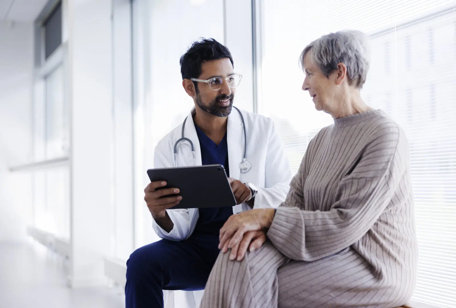 Doctor And Patient In Conversation, Looking At Digital Tablet